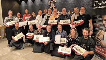 Gruppe hält Backboxen, lächelt drinnen.