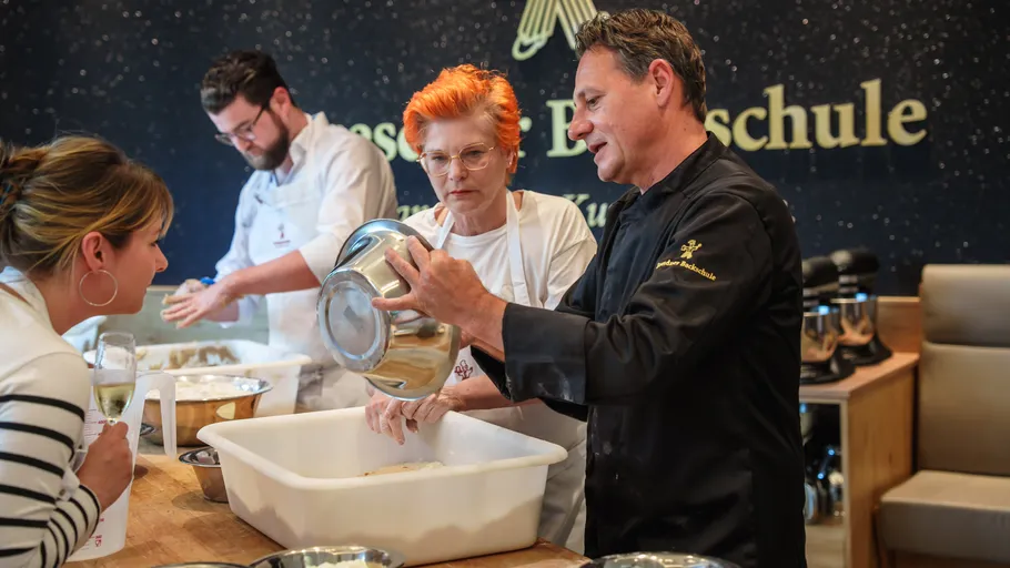 Four people baking in a kitchen class.