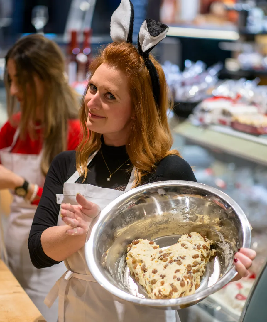 Woman with bunny ears holds heart-shaped dough.