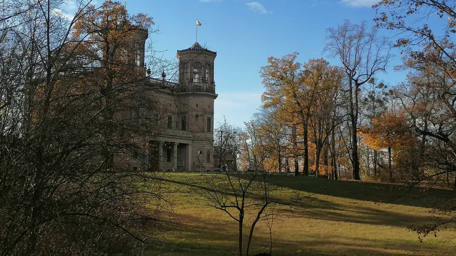 Historisches Gebäude von Herbstbäumen umgeben.