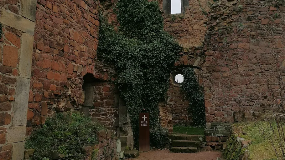 Ruinen mit efeubedeckten Ziegelwänden und Bogenfenstern.