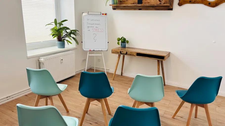 Stühle im Kreis angeordnet, Flipchart daneben.