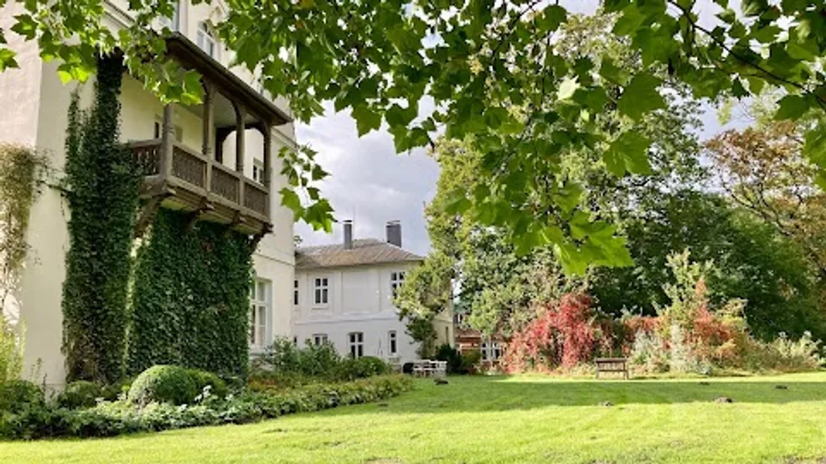 Haus mit Efeu in üppigem Gartensetting.