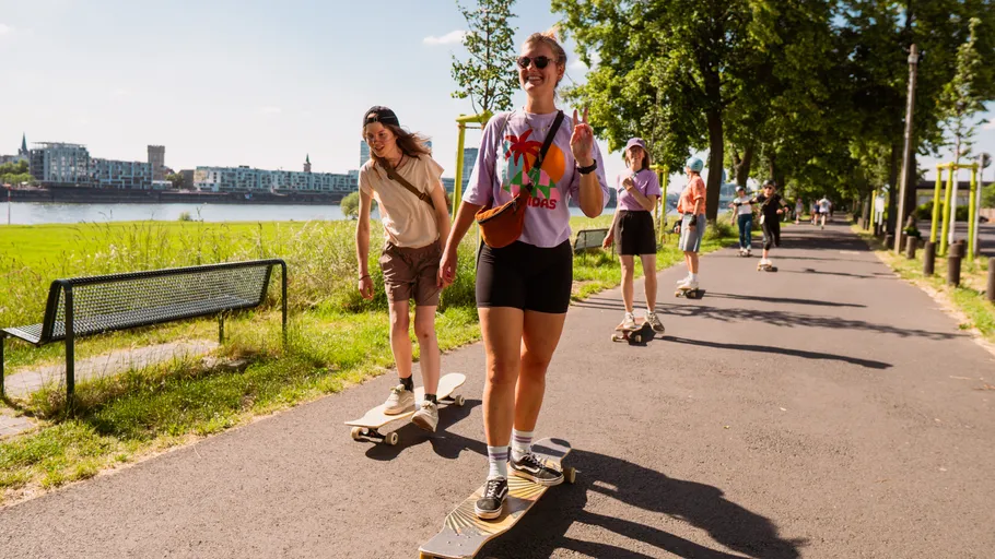 Gruppe von Personen skatet entlang Flussweg.