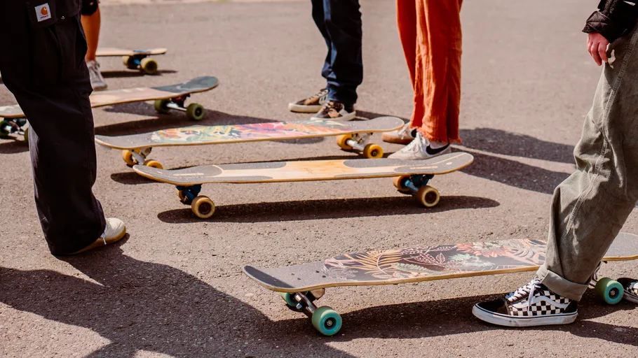 Skateboards auf Asphalt umgeben von Menschen.