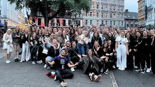 Large group celebrating outdoors in a city square.