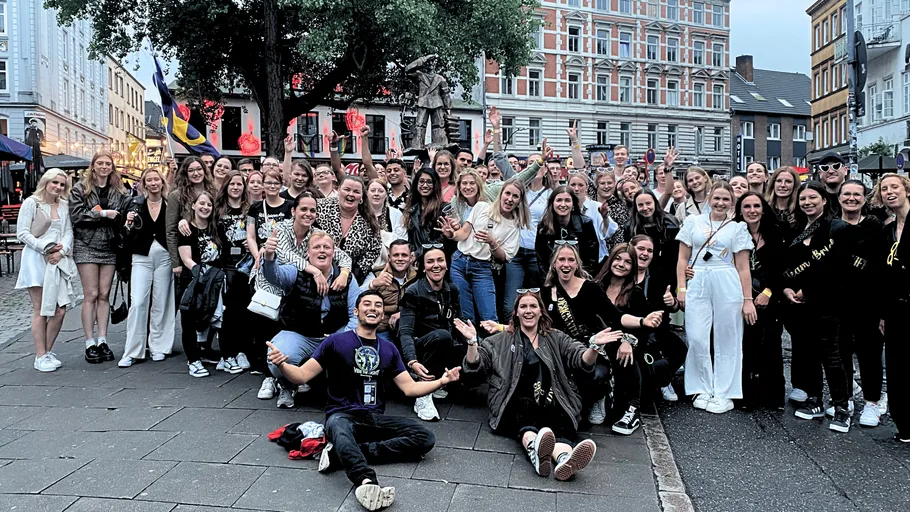 Large group celebrating outdoors in a city square.