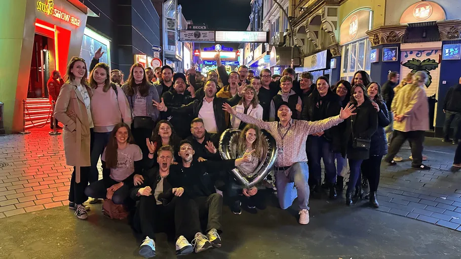 Group posing, lively street, night scene.