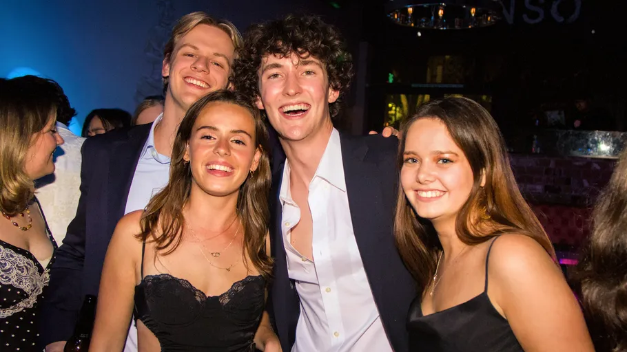 Gruppe junger Erwachsener lächelt auf einer Party.