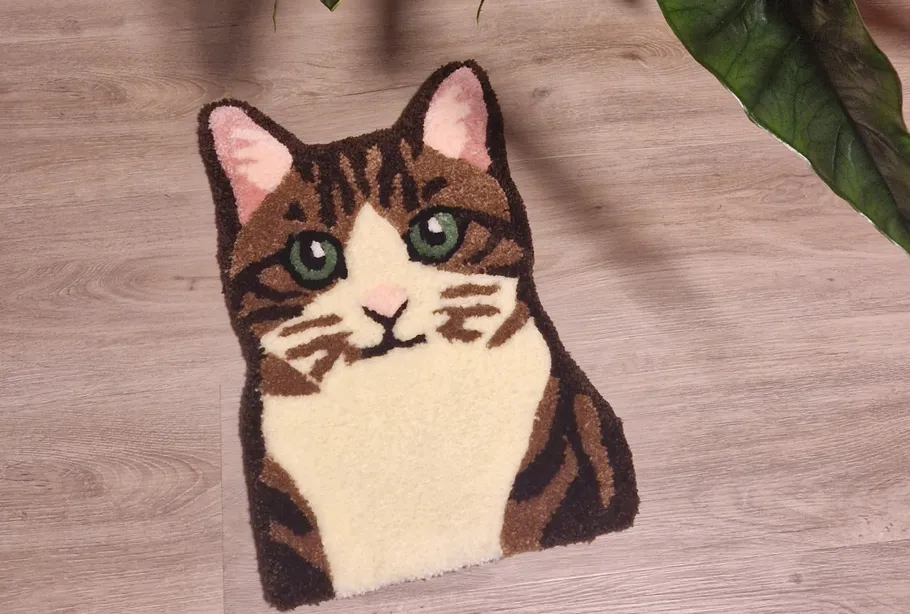 Katzenförmiger Teppich auf Holzboden, Pflanze in der Nähe.