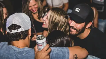 Menschen lächelnd und umarmend auf lebhafter Party.