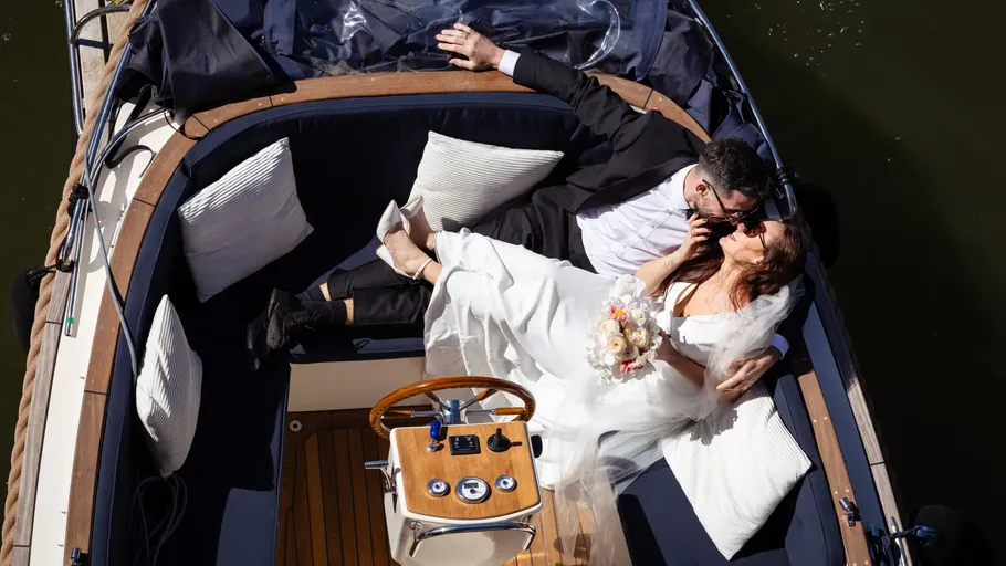 Couple relaxing on a boat, embracing and smiling.