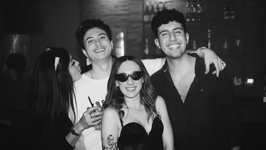 Four friends smiling at a bar.