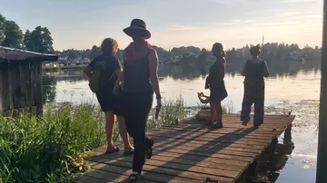 People walking on a lakeside wooden dock.