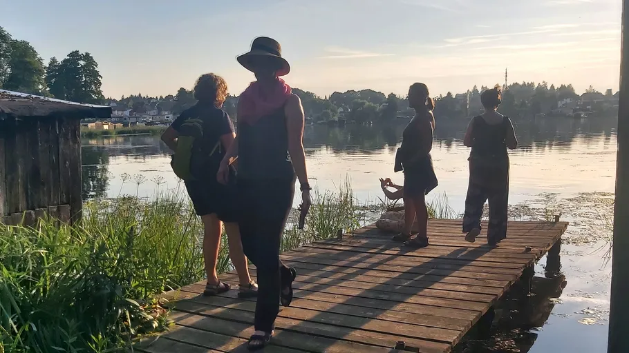 People walking on a lakeside wooden dock.