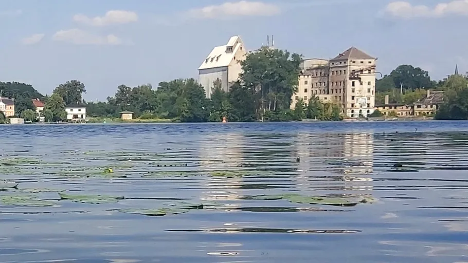 Gebäude spiegeln sich auf ruhigem See.