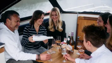 Menschen genießen Getränke auf einem Boot.