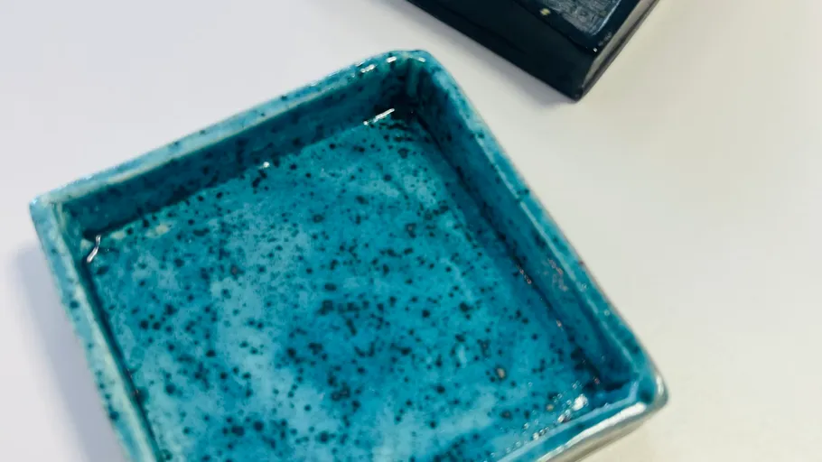 Blaues Keramikgeschirr auf weißer Oberfläche.