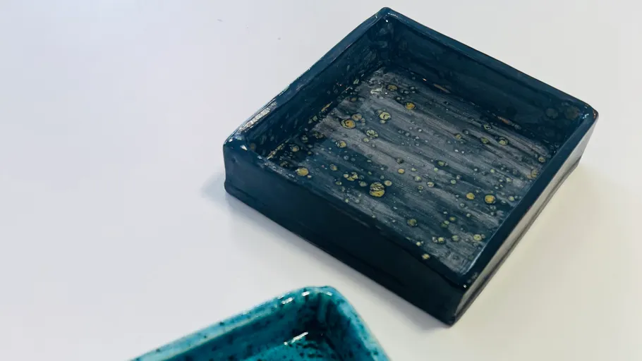 Two square ceramic trays on a white surface.