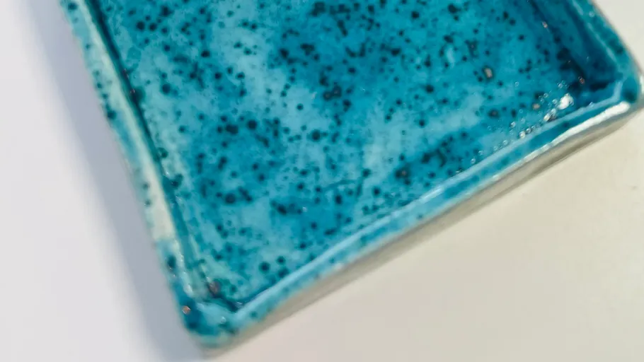 Blau gesprenkeltes Keramiktablett auf weißer Oberfläche.