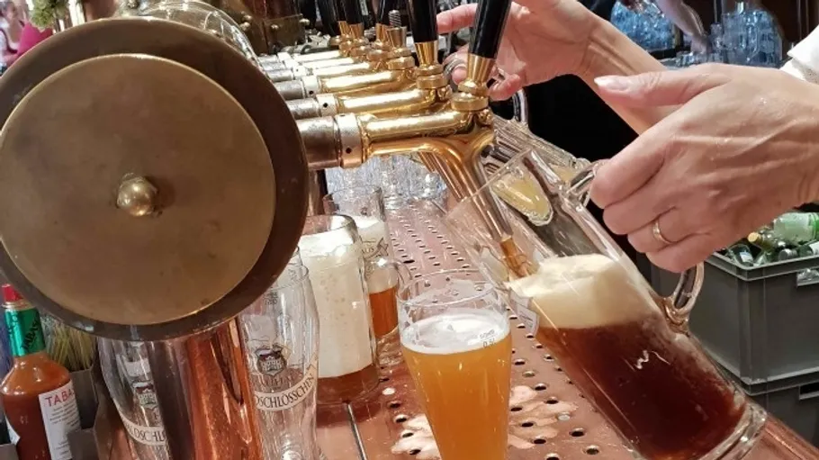 Hands pouring beer from golden taps.