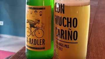 Flasche und Glas auf Holztisch.