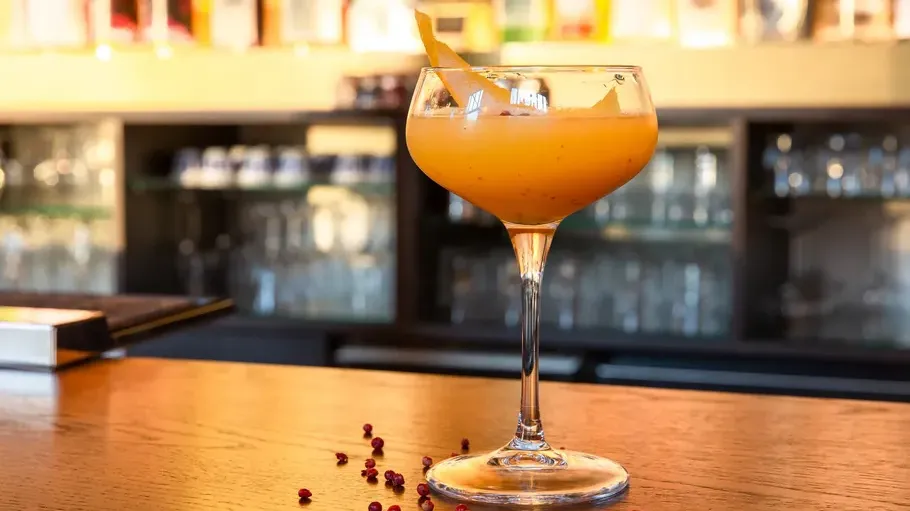 Oranger Cocktail auf Bartresen.