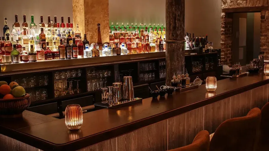 Bar counter with bottles and warm lighting.