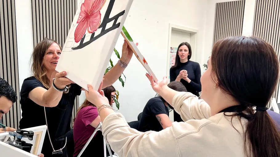 Frauen tauschen Gemälde im Kunstkurs aus.