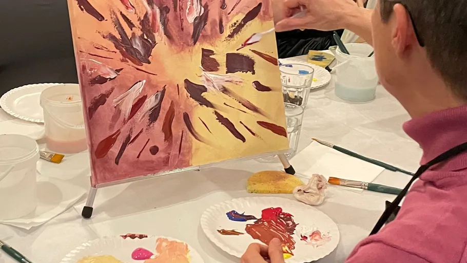 Person painting abstract artwork on canvas.
