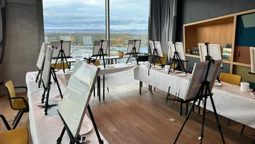 Empty easels in a studio with window view.