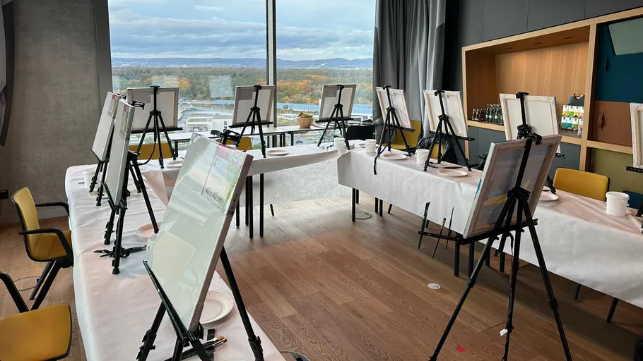 Room with easels on tables, city view outside.