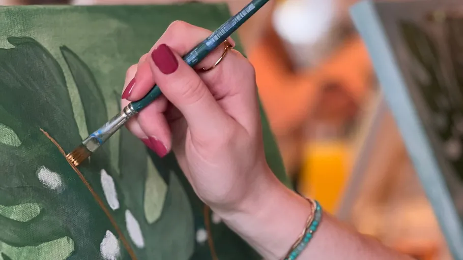 Hand painting green leaf on canvas.
