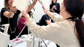 People exchanging paintings at an art workshop.