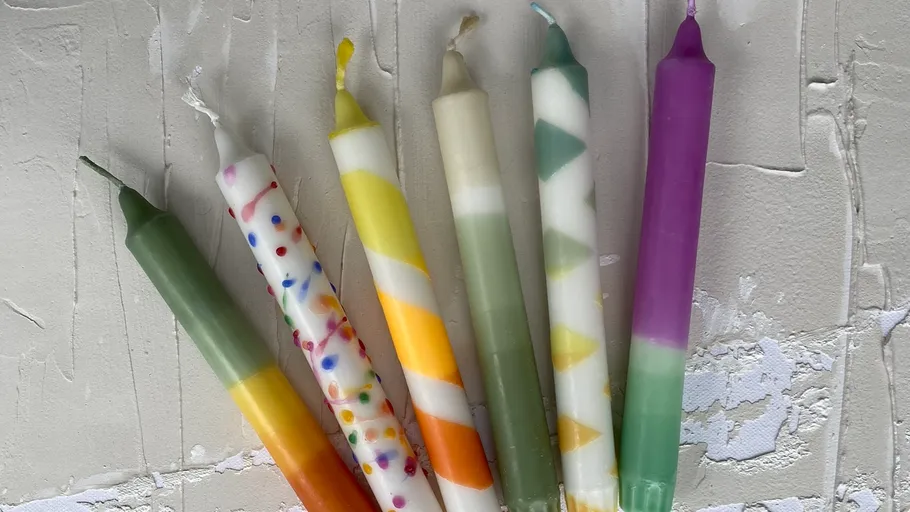 Bunte Kerzen auf strukturierter Oberfläche.
