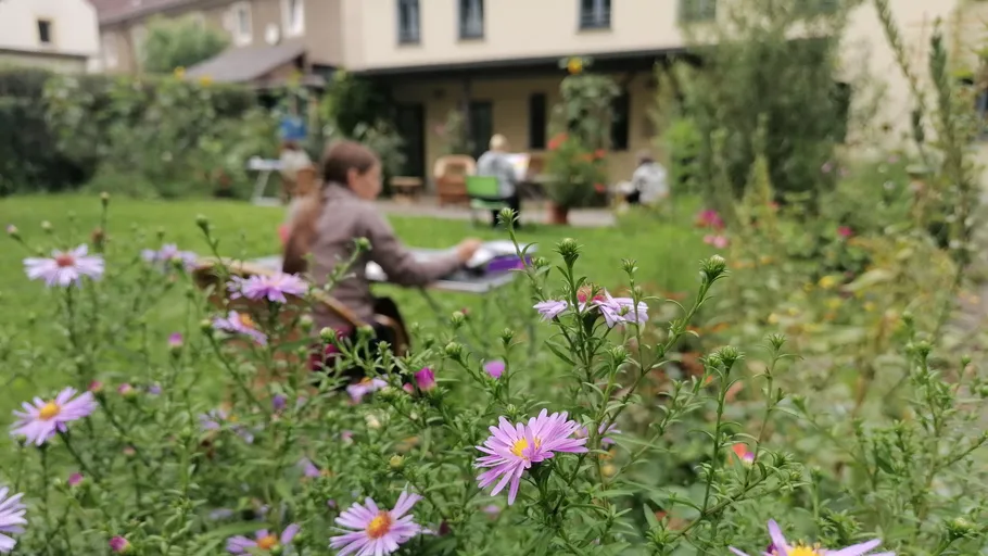 Lila Blumen mit Menschen unscharf im Hintergrund.