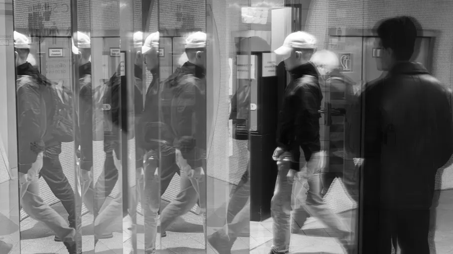 People walking through a revolving door.