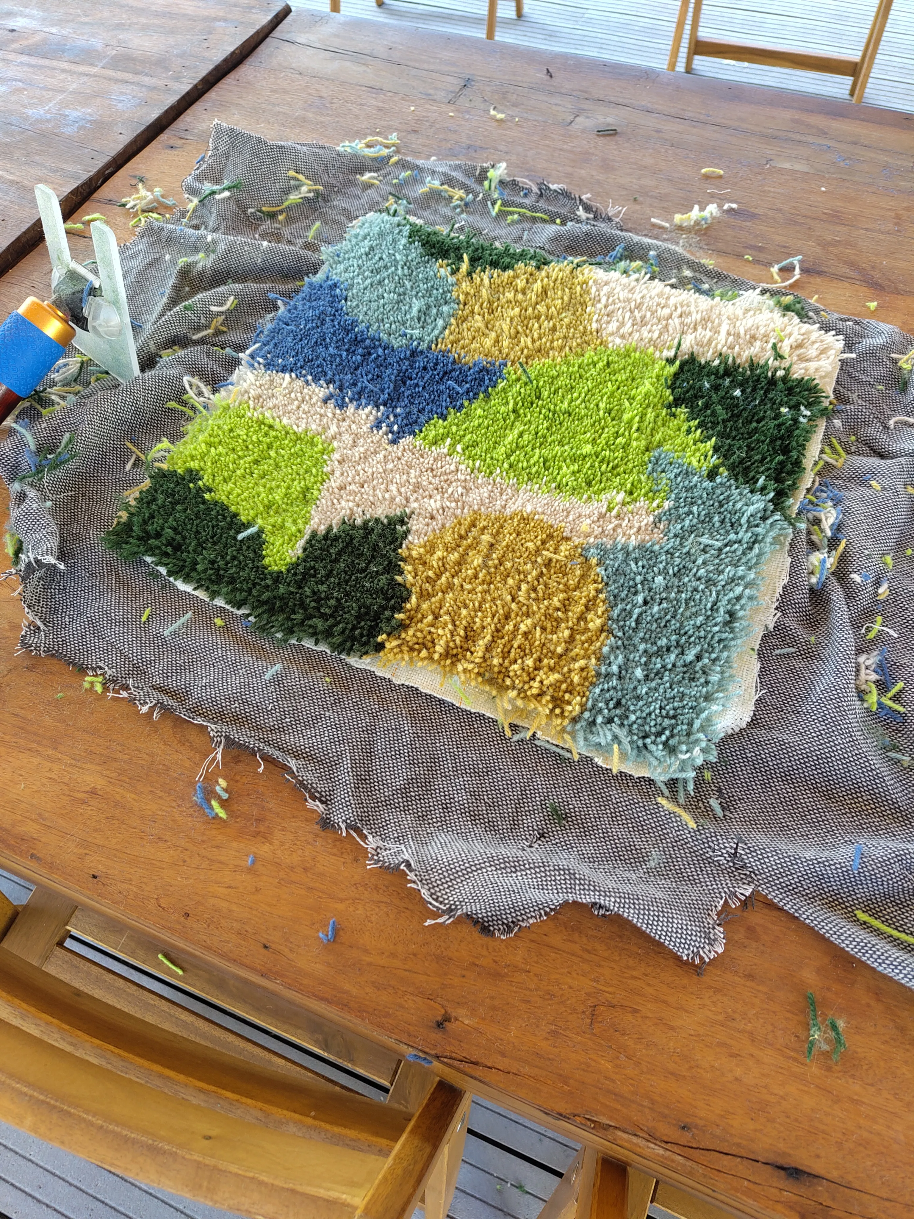 Bunter handgefertigter Teppich auf Holztisch.