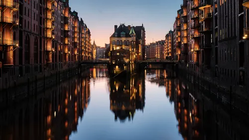 Historic warehouse district at dusk, illuminated buildings.