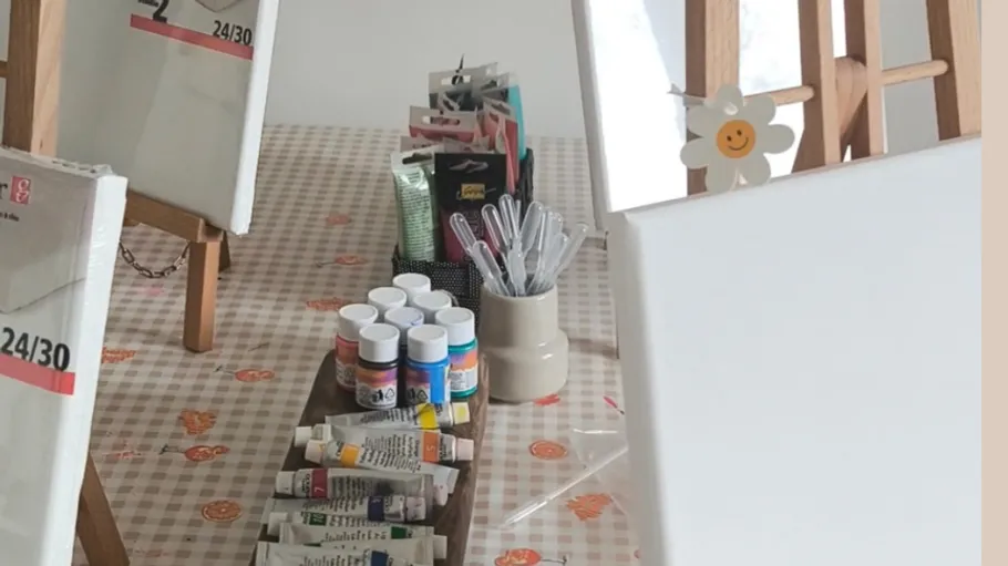 Kunstmaterialien auf einem Tisch mit Staffeleien.