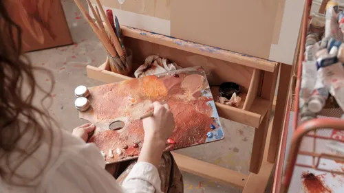 Künstler mischt Farben auf Palette im Atelier.
