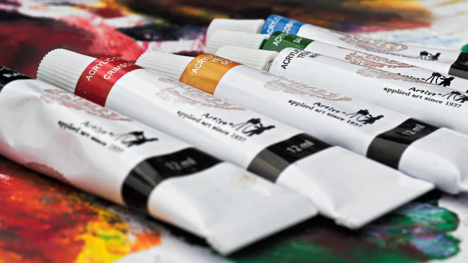 Acrylfarbtuben auf bunter Malfläche.