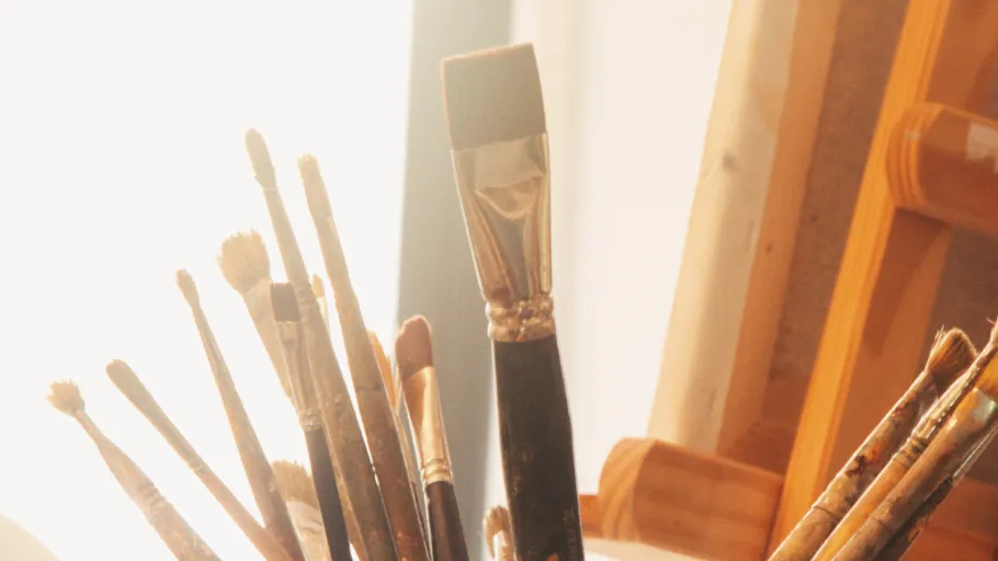Paintbrushes in a metal can on an easel.
