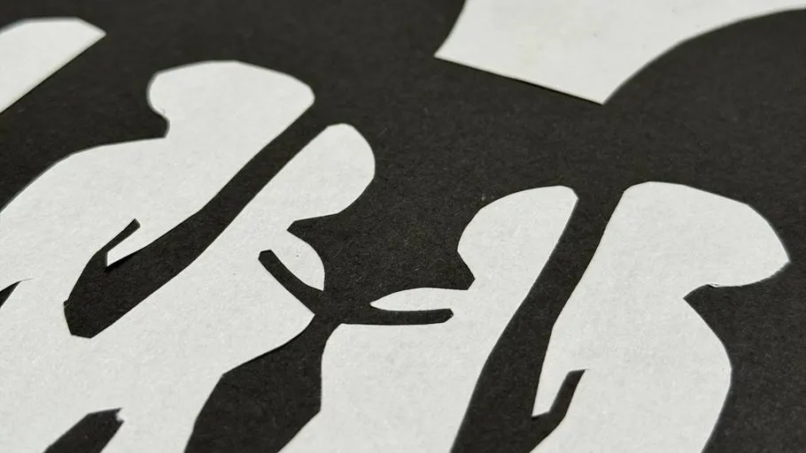 White paper cut-outs on black background.