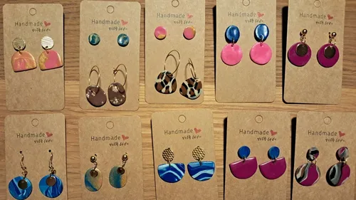 Handmade earrings displayed on cardboard cards.