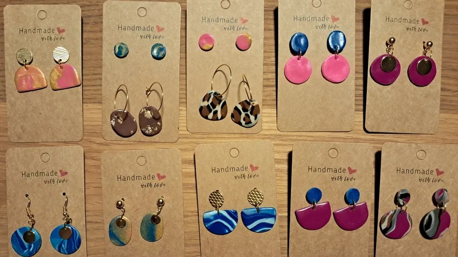 Handmade earrings displayed on cardboard cards.