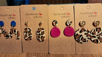Four pairs of handmade earrings on display cards.