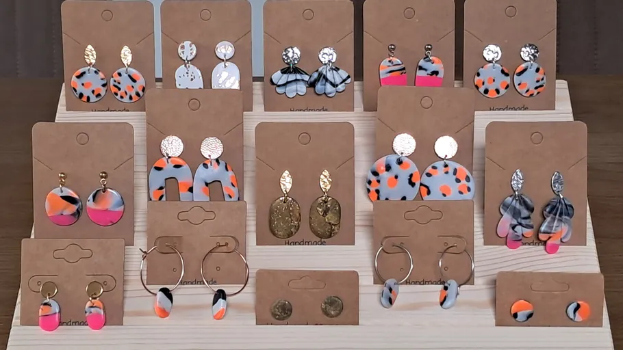 Earrings displayed on wooden stand indoors.