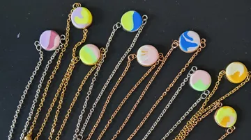 Colorful pendants on chains against black background.