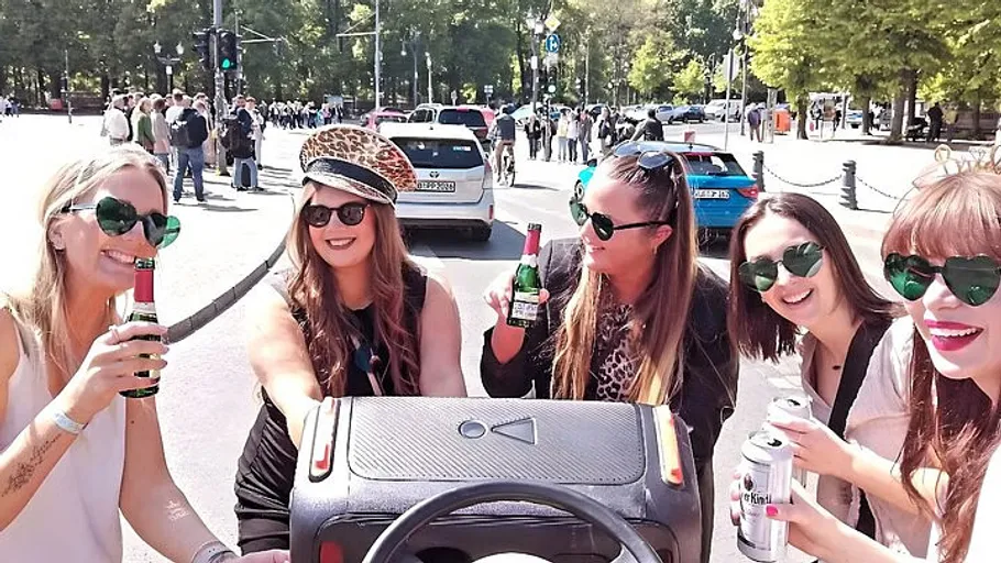Fünf Frauen trinken Bier auf einer Stadtstraße.